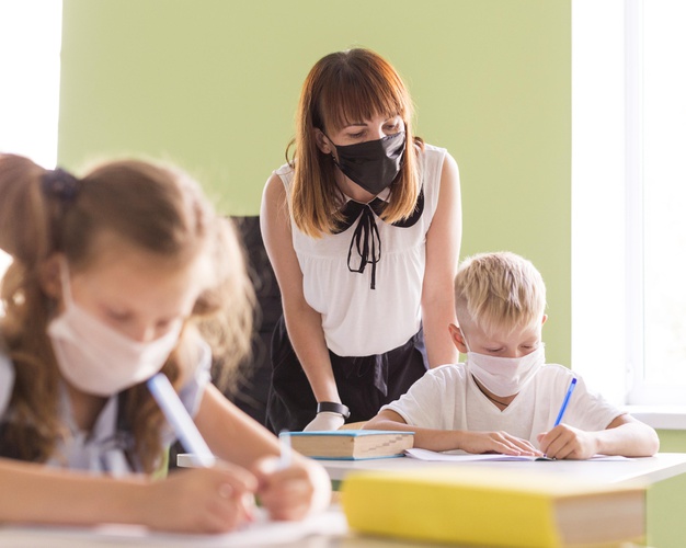 maestros-ninos-protegiendose-mascarillas-clase_23-2148673970